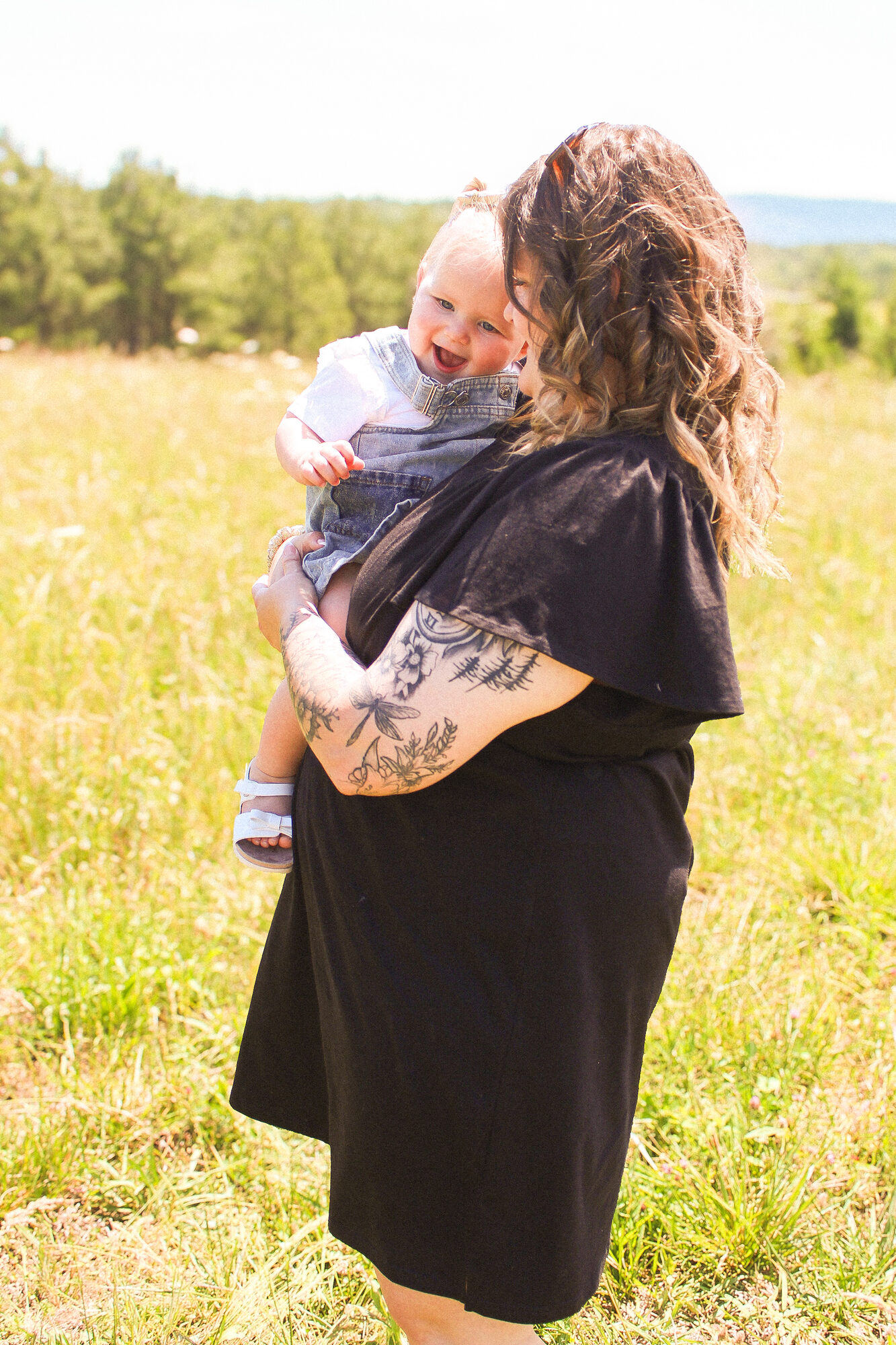 Mother holding her baby in a sunlit field